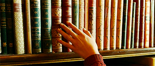 Hand trailing along a neat row of books